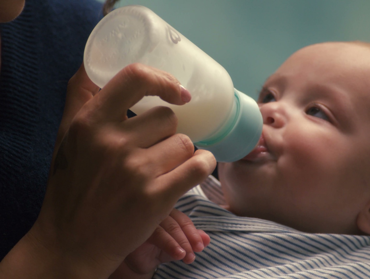A parent feeding a baby from a Bond bottle