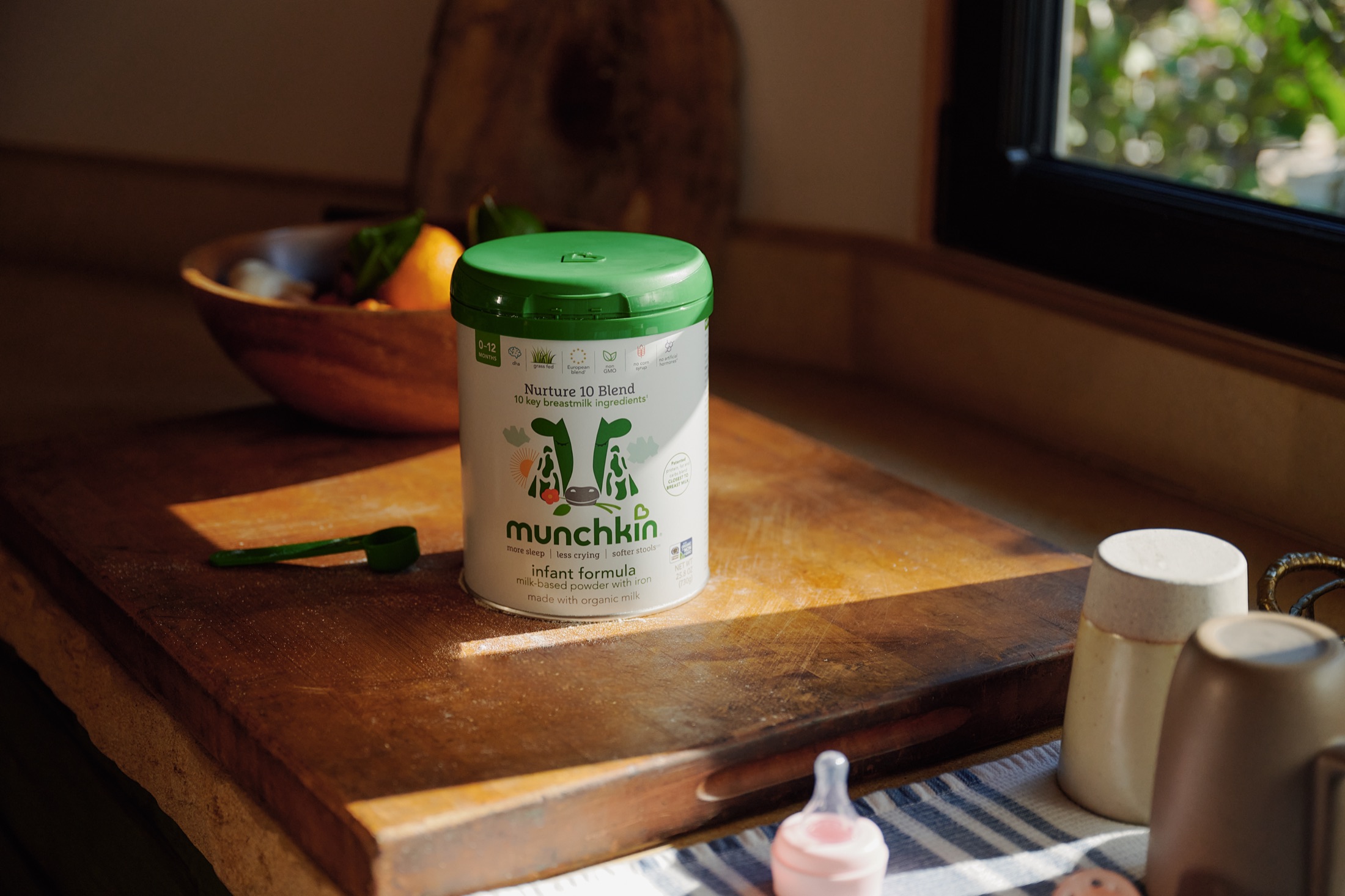 Munchkin infant formula can on a sunlit wooden counter