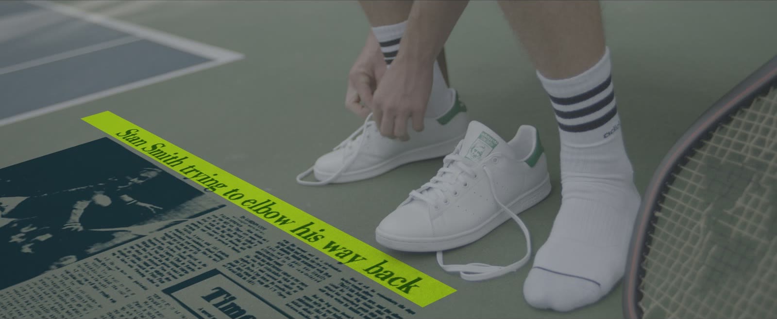 Hands tying white Stan Smith sneakers beside a newspaper clipping